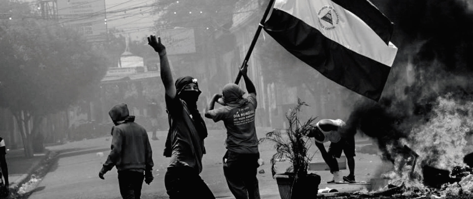 Jóvenes alzando la bandera de Nicaragua durante una protesta